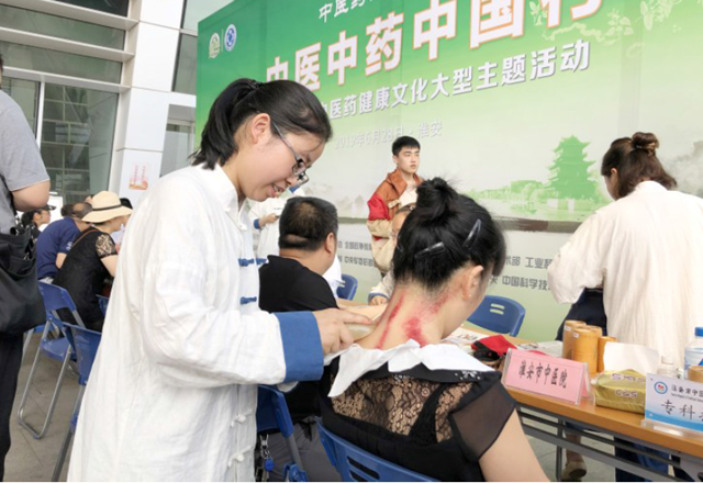 图为中医师在江苏省淮安市政r务服务中心为当地群众刮痧